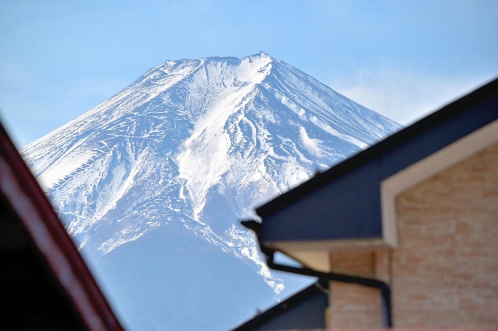 a snow covered mountain is seen through a car window at APROSTAY Fuji-kawaguchiko Aizen15 in Fujiyoshida