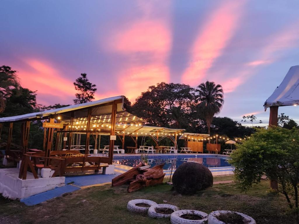 a building with a pool with a sunset in the background at Bocuare Jungle in Tapantí