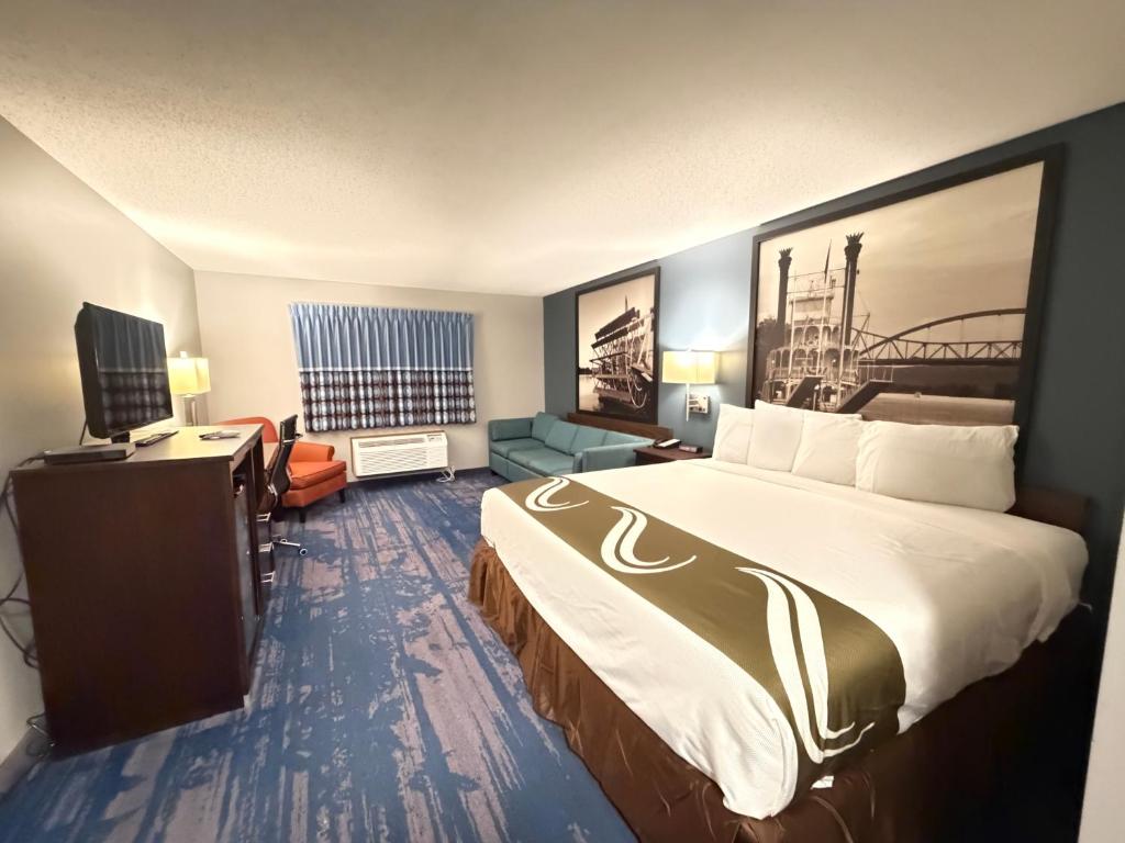 a hotel room with a large bed and a television at Northwood Inn - Prairie Du Chien in Prairie du Chien