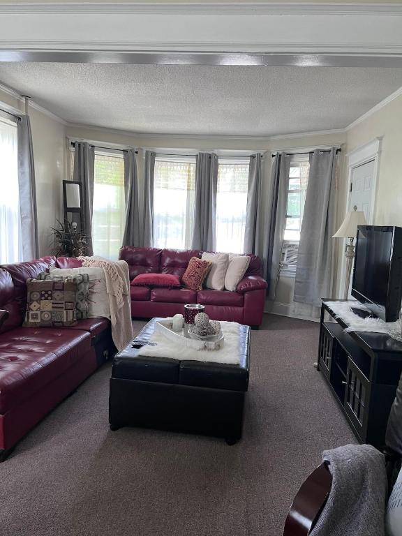 a living room with red couches and a tv at Eden's Cozy Oasis in Windsor