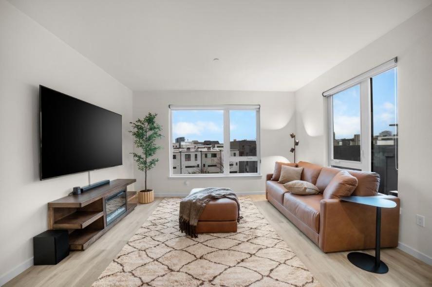 a living room with a couch and a flat screen tv at Modern Lux Midrise Stadium & Downtown Views in West Sacramento
