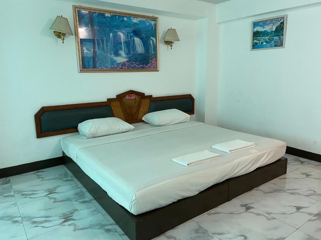 a bedroom with a bed with two books on it at โรงแรมโกลเด้นแกรนด์ พิษณุโลก in Phitsanulok