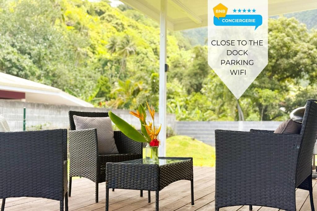 a patio with chairs and a table and a sign at Quiet house - great mountain view in Tiaraha