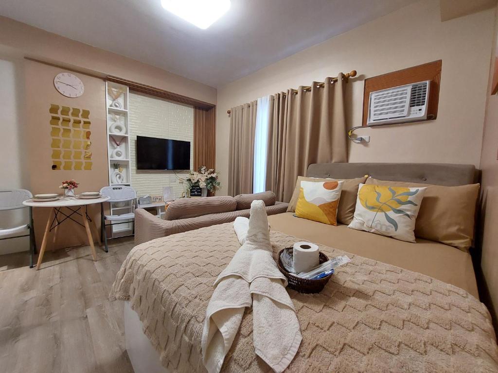 a bedroom with a bed and a living room at Jade's Place Condo in Bacolod