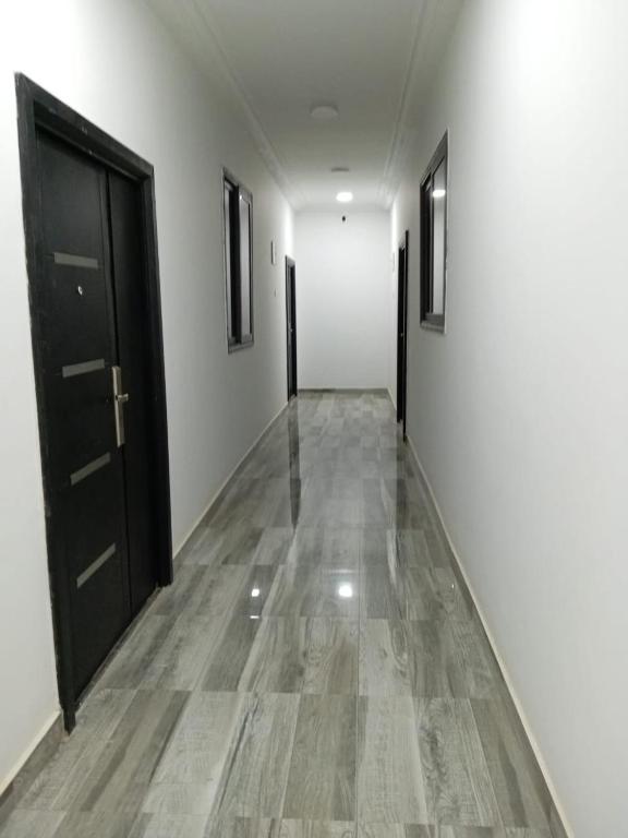 an empty hallway with black doors and white walls at Luxury Live Inn Suite in Owuraman