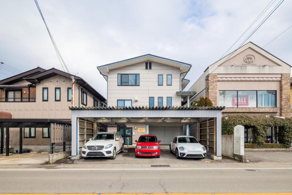 three cars parked in a garage in front of a house at Tabiudo Souwa in Takayama