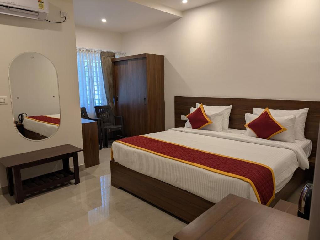 a bedroom with a bed with a mirror and a table at Hanuman Heritage in Chikmagalūr