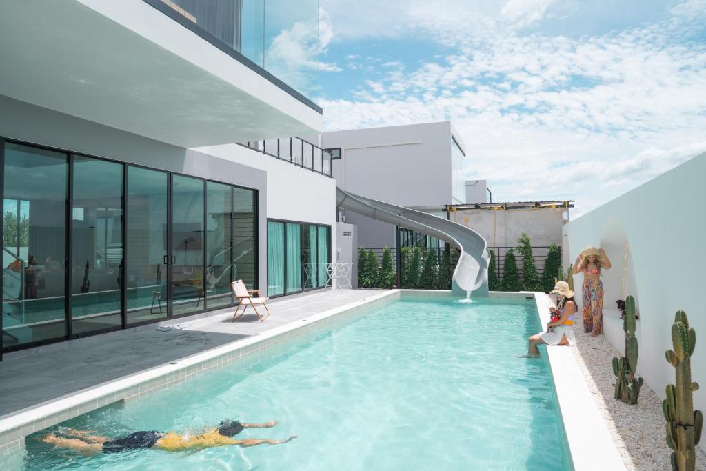 a woman laying in a swimming pool in a house at The Moon Huahin Pool Villa in Hua Hin
