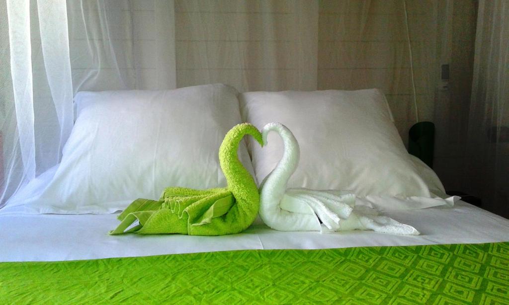 two swans sitting on top of a bed at Le Refuge du Bon Repos in Le Lorrain