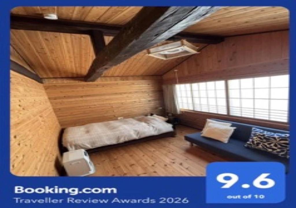 a bedroom with a bed and a couch in a room at 田舎の別荘 かすみ草 in Shōgahora