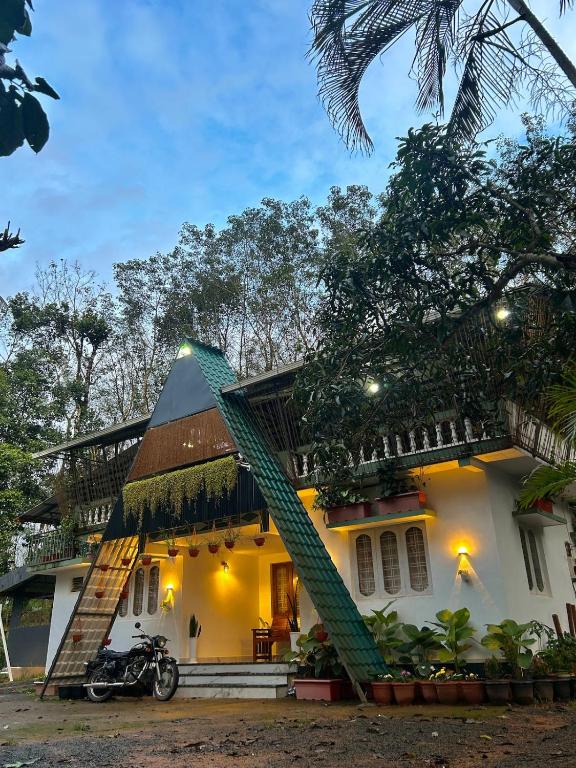 a house with a motorcycle parked in front of it at Neelees Retreat in Kaniyāmbetta