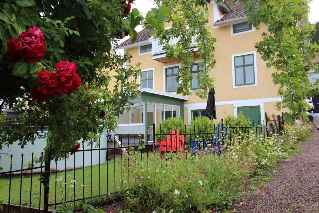 a fence in front of a house with red roses at Sjögatan 21, in Gränna