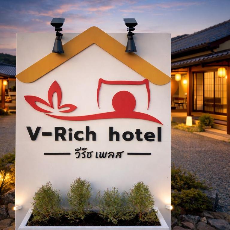a sign for a v rich hotel with lights on it at V Rich วีริชเพลส ร้อยเอ็ด in Ban Non Muang