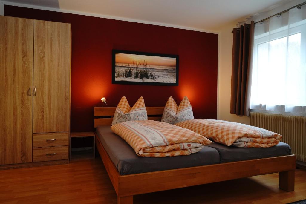 a bedroom with a bed with a red wall at Ferienwohnung Schog in Todtnau