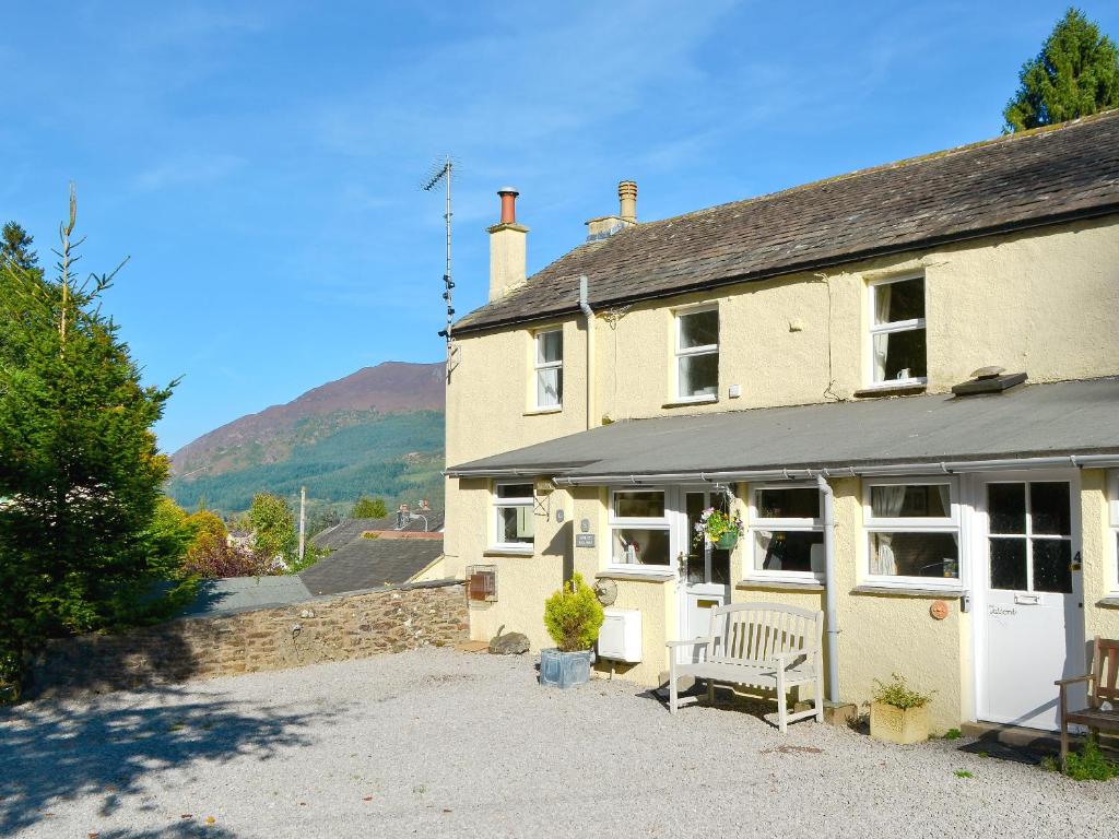 a house with a bench in front of it at Harriet's Hideaway in Braithwaite