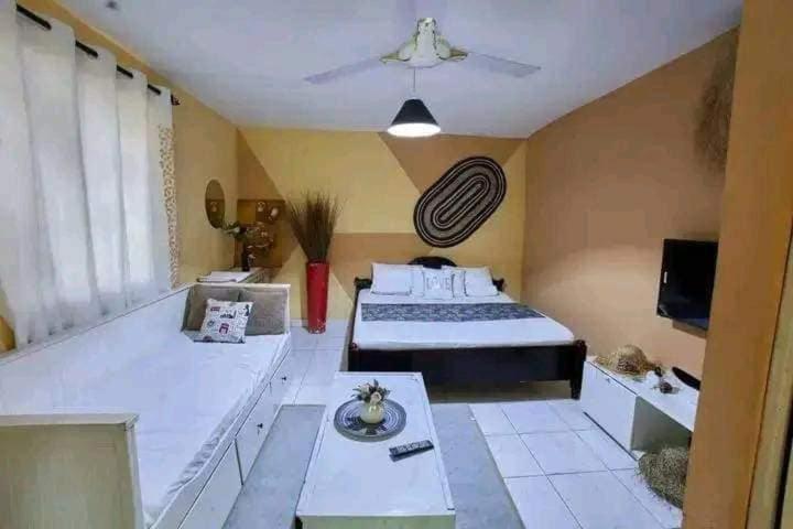 a large room with a bed and a tv at Masai Apartments Diani in Ukunda