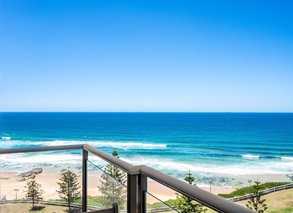 a view of the ocean from the balcony of a beach at Seaside Luxe - L8 - Local Eats, Walks, Swims, CBD in Newcastle