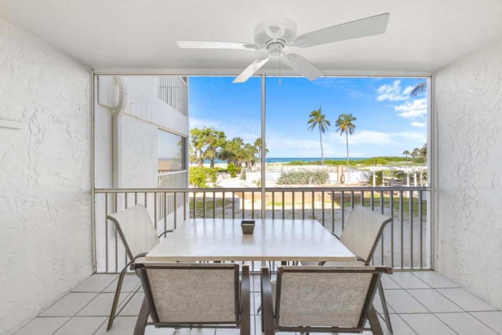 a table and chairs on a balcony with a view of the ocean at Beach Villas 2514 condo in Captiva