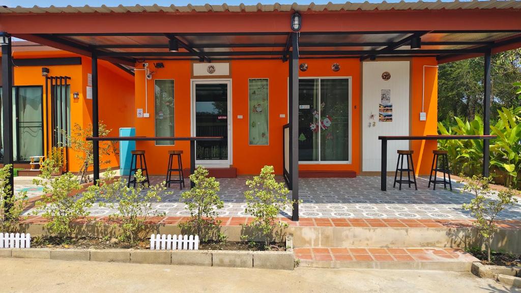 an orange building with tables in front of it at Thung Setthi Homestay&Cafe5 in Chiang Dao