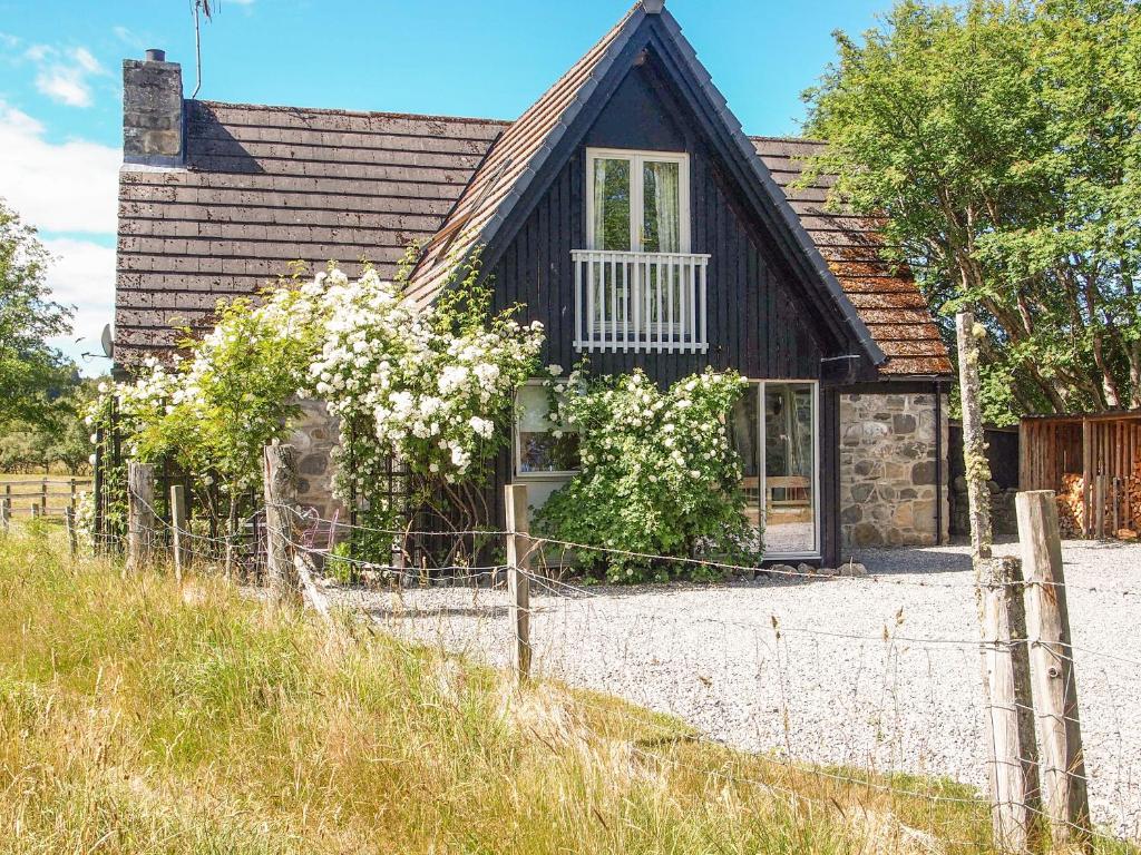 a house with a fence in front of it at Inshcraig in Kincraig