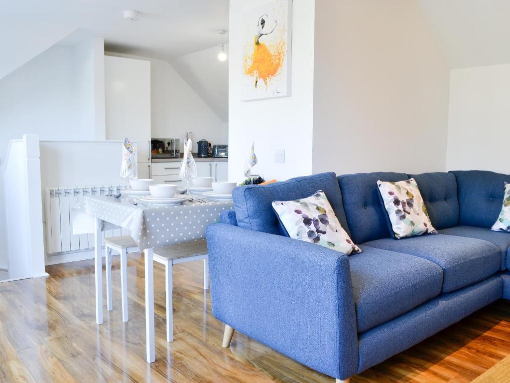 a blue couch and a table in a living room at 3 Old Posting Stables in Gatehouse of Fleet