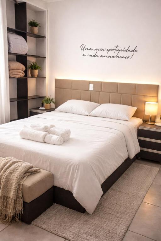 a bedroom with a large bed with towels on it at Studio Central - Climatizado - Prático in Erval dʼOeste