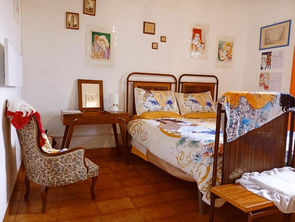 a bedroom with a bed and a table and a chair at Casetta dei Nonni in Vitorchiano