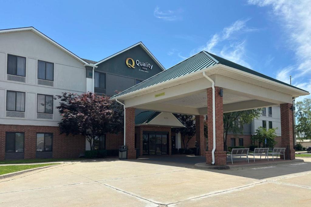 a hotel building with awning in a parking lot at Quality Inn Warrensburg in Warrensburg