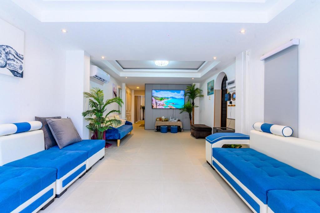 a living room with blue couches and a flat screen tv at Mountain View Escape at Primrose Hill in Bangrak Beach