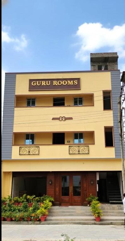 a building with a sign for a hotel at Guru Rooms in Tiruvannāmalai