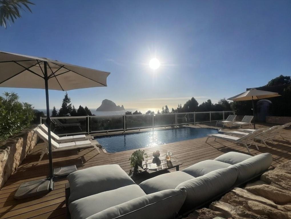 a swimming pool with lounge chairs and an umbrella at Casa Panorama in Illes Balears