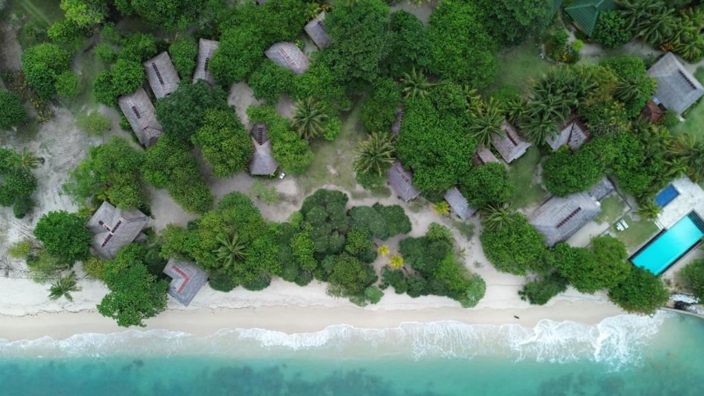 an overhead view of a beach with houses and trees at Trikora Beach Club and Resort in Telukbakau