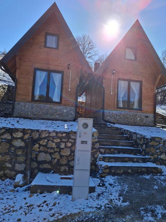 a house with snow on the ground in front of it at Vikendica Neven 3 in Popovići