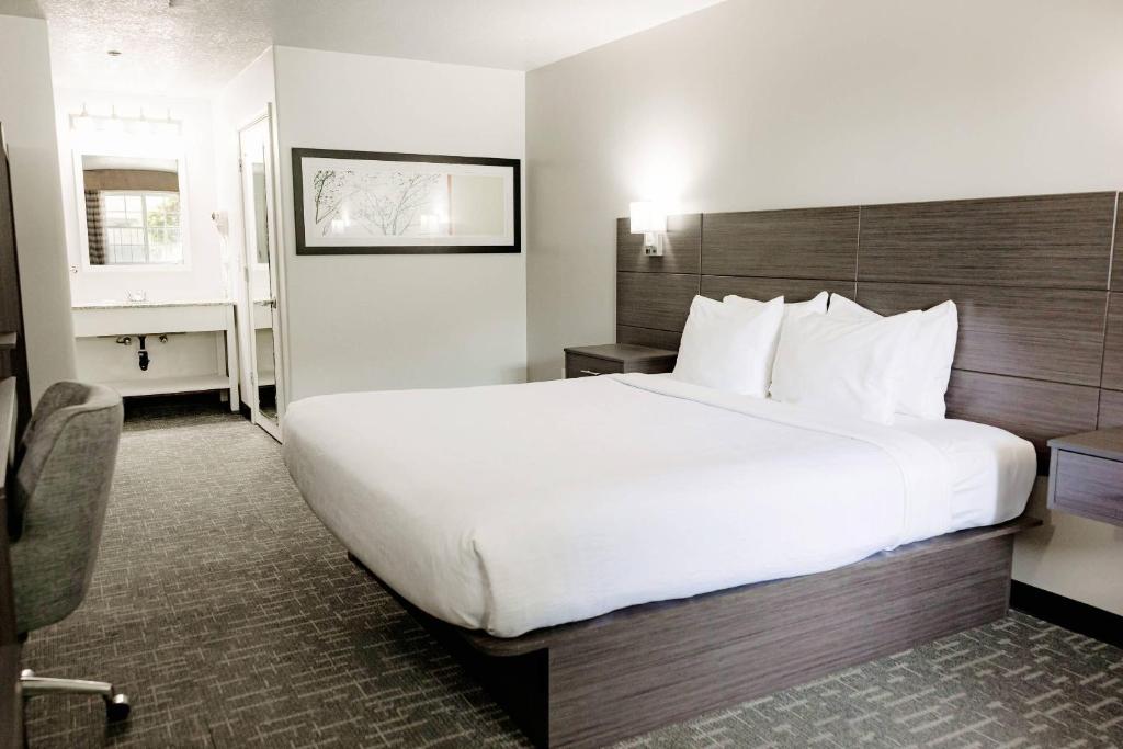 a large white bed in a hotel room at Quality Inn & Suites Lathrop in Lathrop