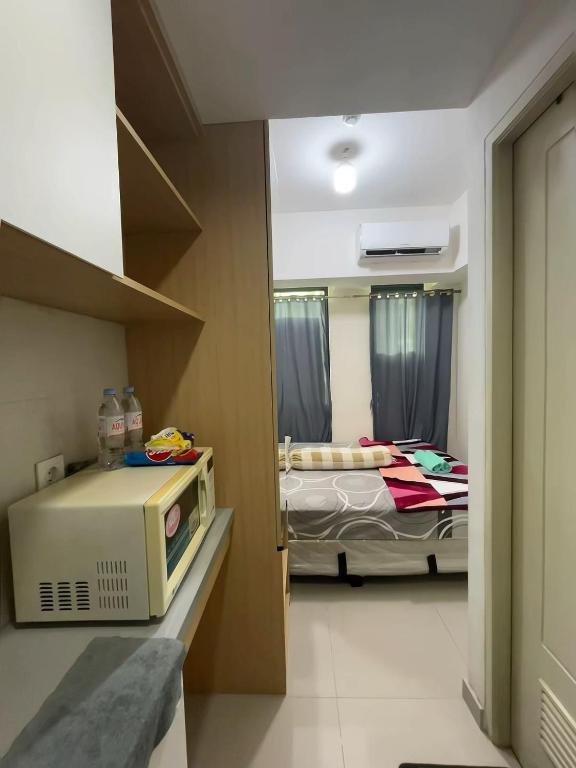 a hospital room with a bed and a microwave at Osaka Riverview Apartment PIK 2 in Rawalumpang