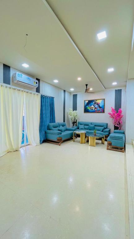 a large living room with blue couches and tables at Shubh causy 4bhk villa in Lonavala