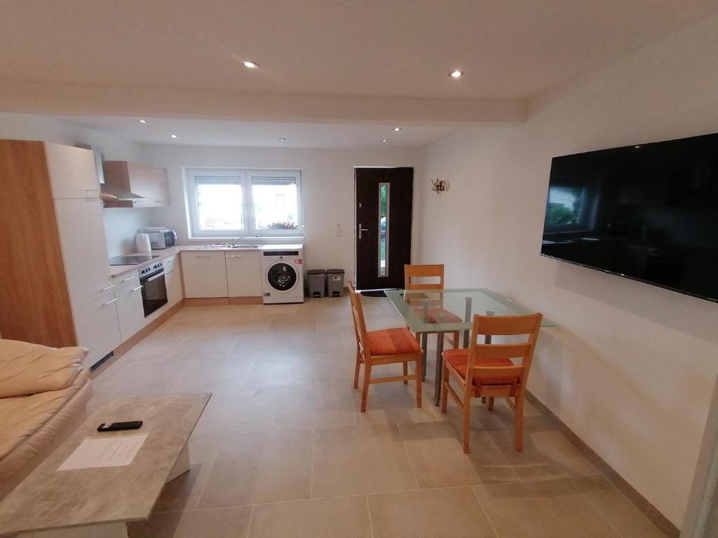 a kitchen and living room with a table and chairs at Little Break in Röfingen