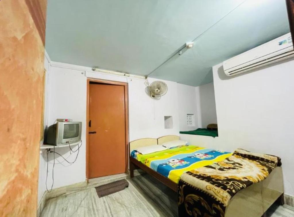 a small bedroom with a bed and a tv at The Jeet Mahal Hotel in Jaisalmer