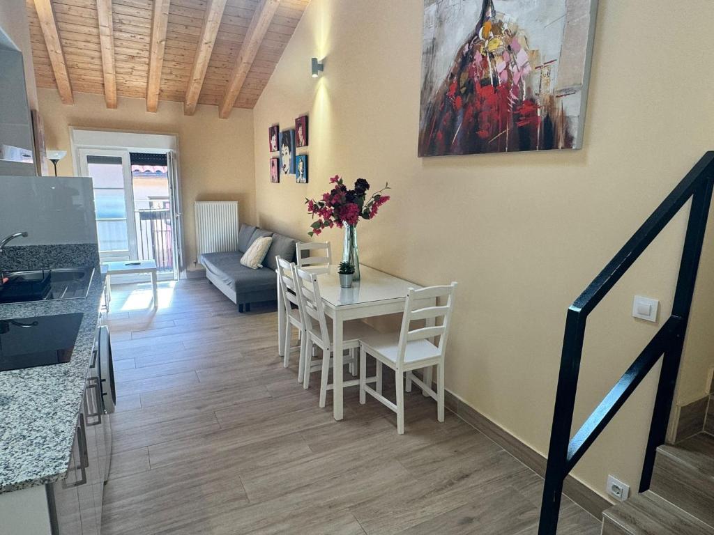 a living room with a table with flowers on it at Apartamentos San Nicolás AIRE AC y ascensor junto a Laurel in Logroño