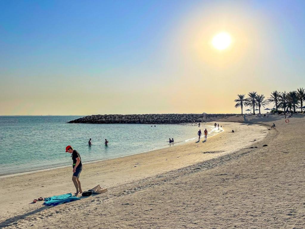 a man standing on a beach with the ocean at FIRST CLASS Studio Pacific Shores Retreat in Ras al Khaimah