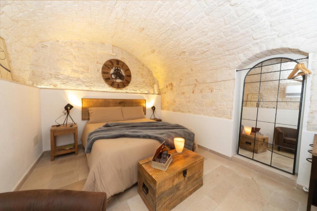 a bedroom with a bed in a room with a brick wall at Himeros Trulli Area in Alberobello
