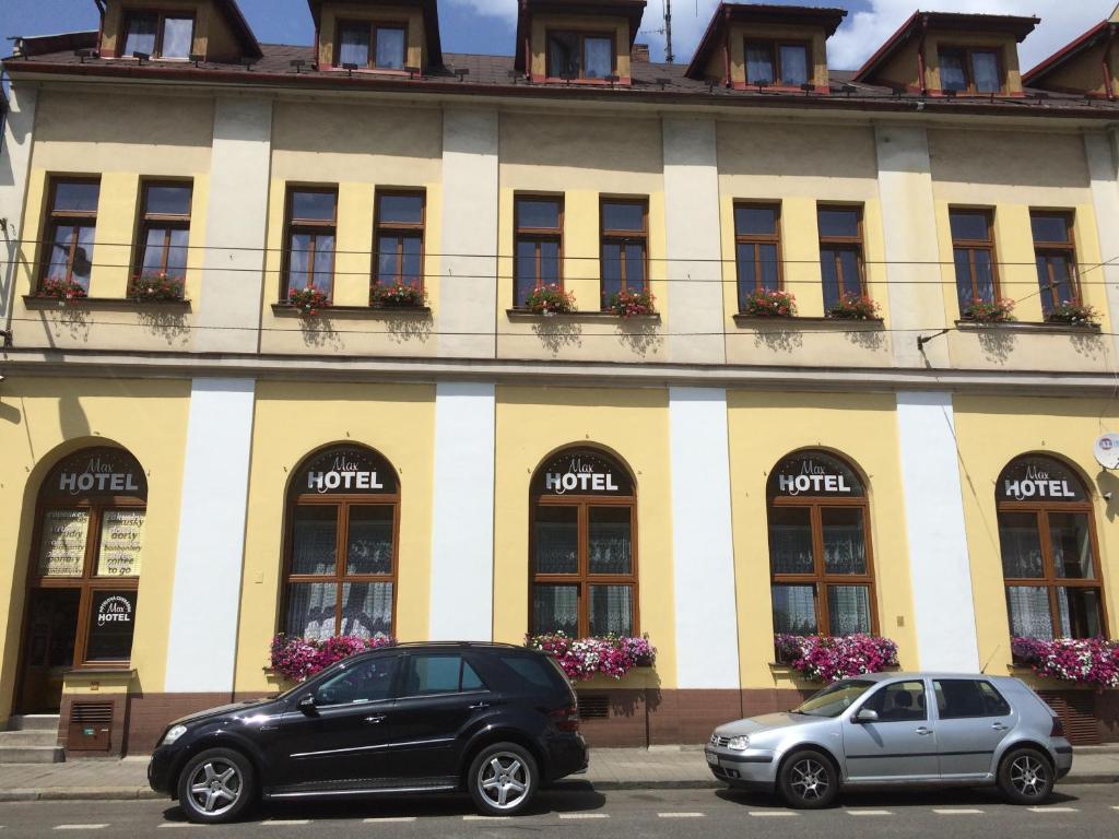 two cars parked in front of a building at Hotel Max Šimek in Ostrava