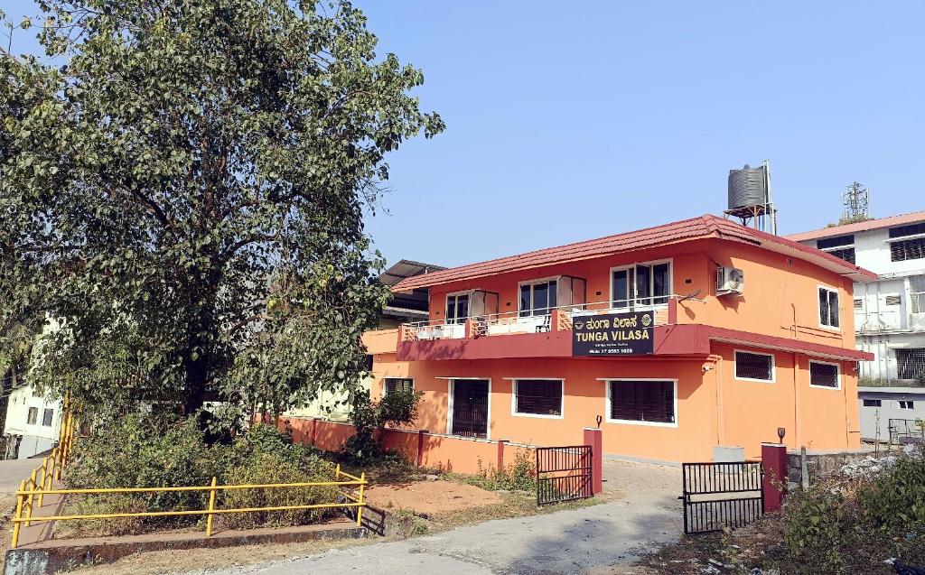 a orange building with a sign on the side of it at Tunga Vilasa in Tīrthahalli