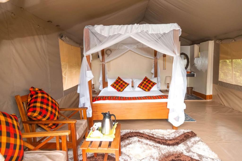 a bedroom with a bed in a tent at Oloimala Mara Camp in Gatunga