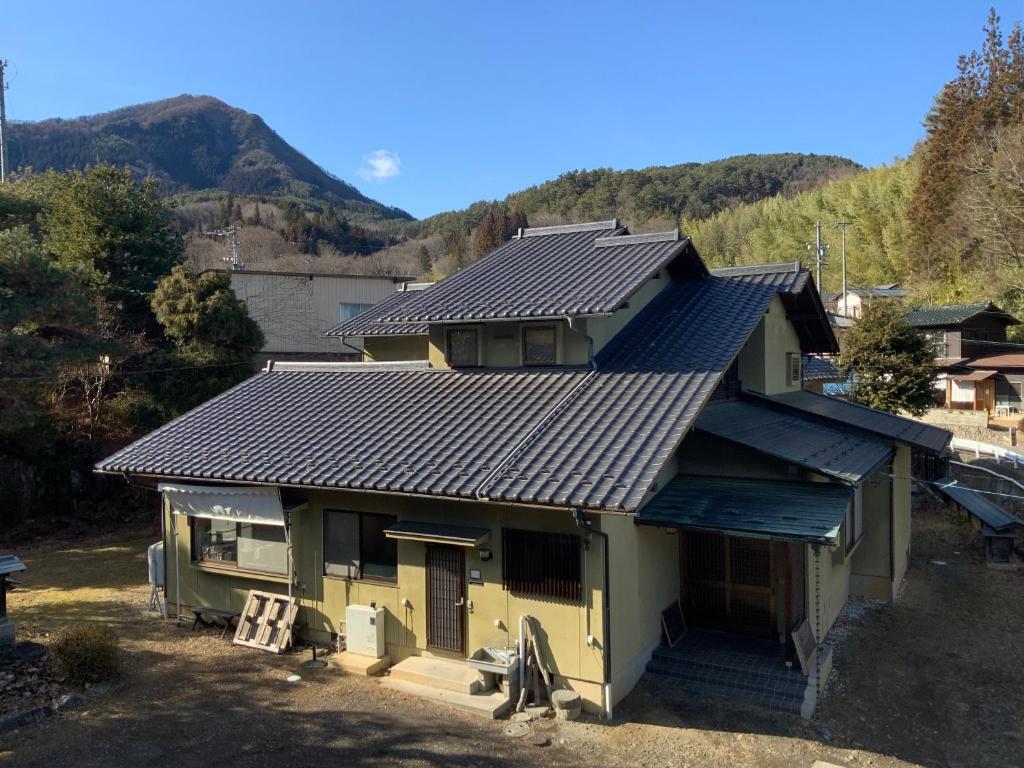 a house with a metal roof on top of it at つむぐ家2 in Ueda