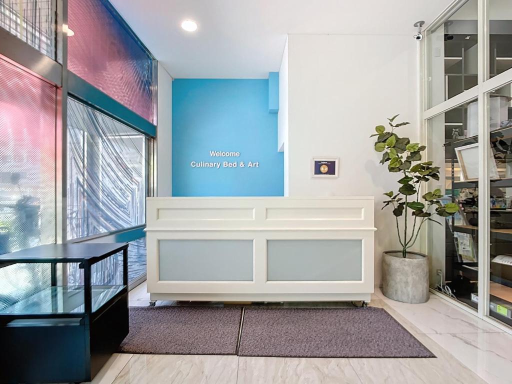 a lobby with a white bench and a blue wall at キュリナリーBed and Art in Hamamatsu