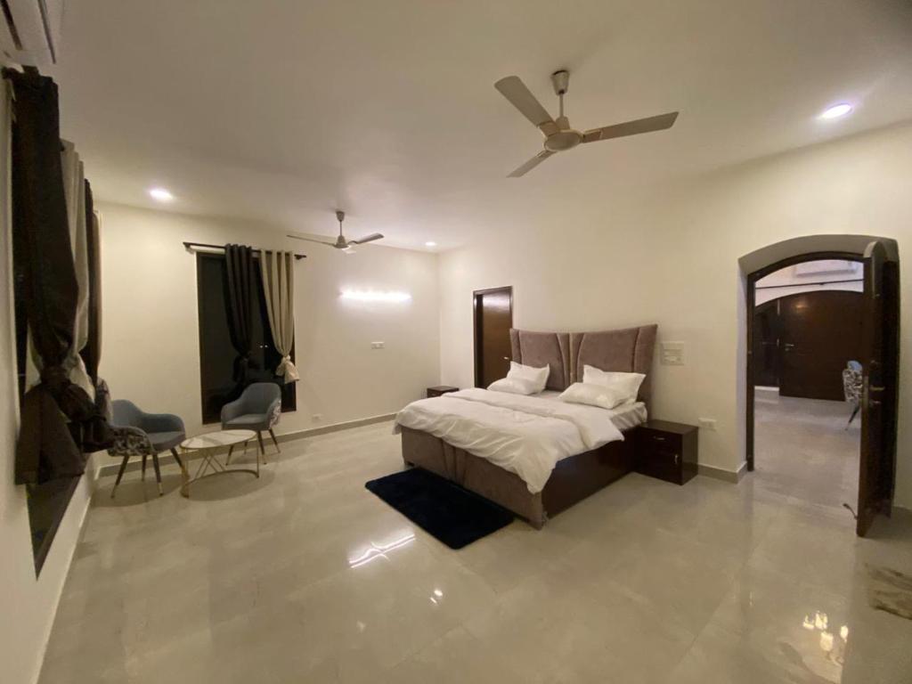 a bedroom with a bed and a ceiling fan at Mitron Farms in New Delhi