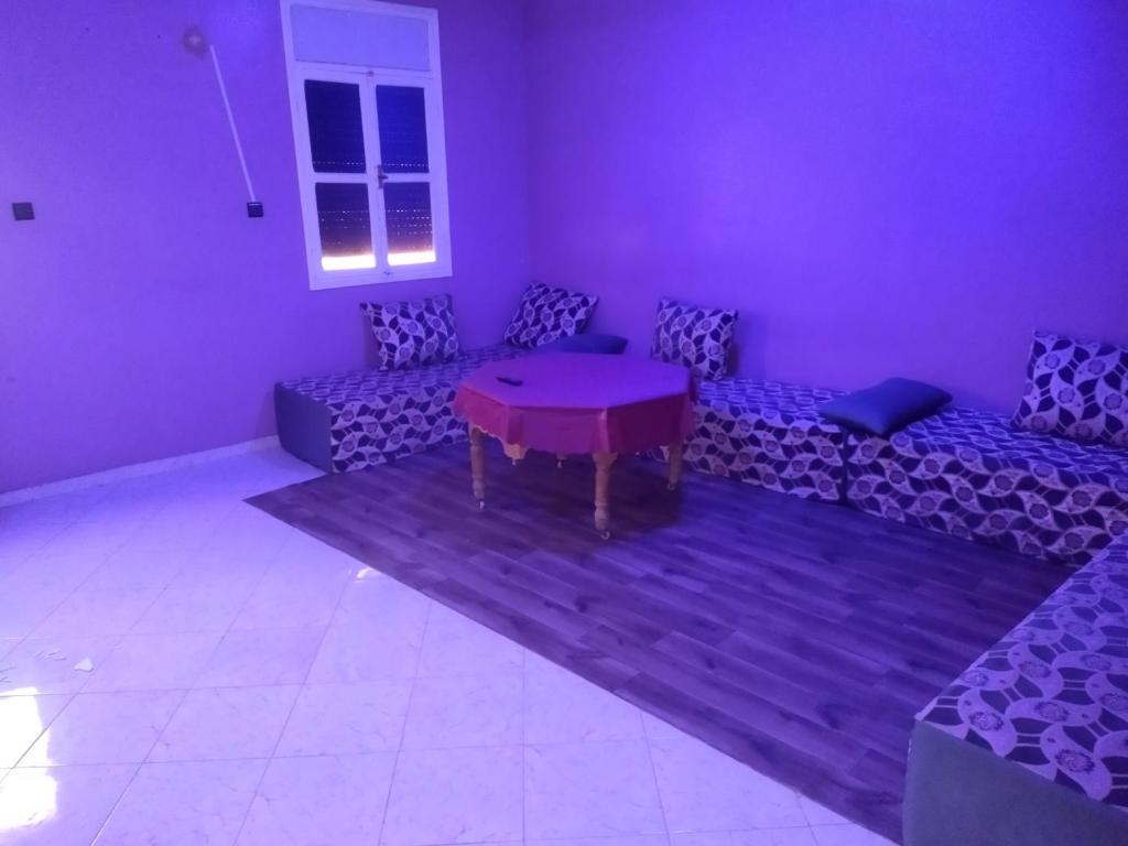 a purple room with couches and a table in it at شقق الخيالي 2 in Tan-Tan