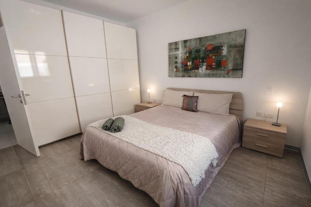 a bedroom with a bed and a painting on the wall at Modern Double Room in Peaceful Pembroke just Minutes away from St Julians in Pembroke