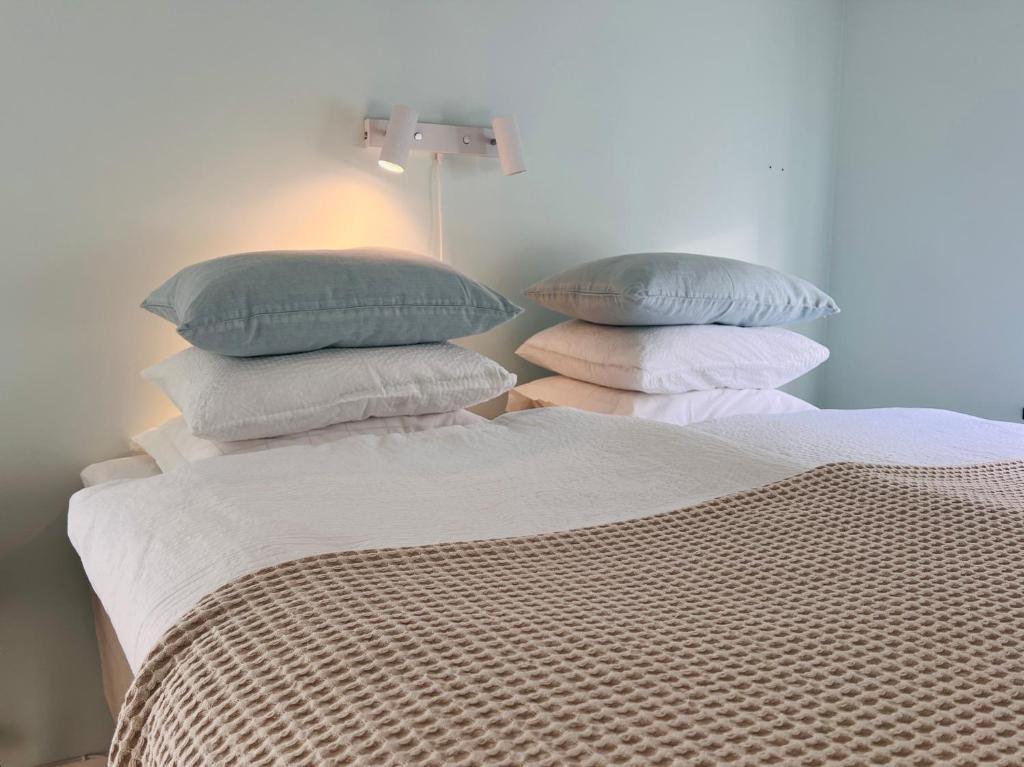 a bed with four pillows on top of it at Tiny flat - in medieval Ystad in Ystad